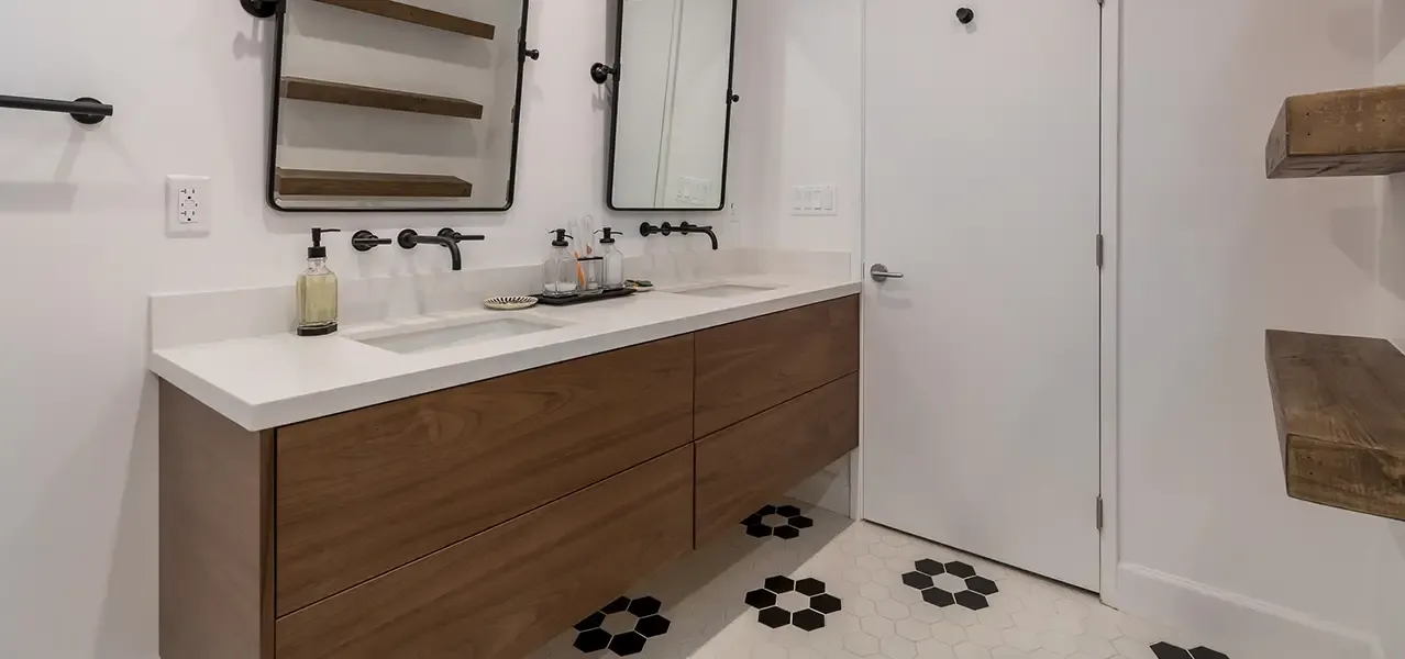 Modern bathroom with white walls, wood vanity, and black accents.