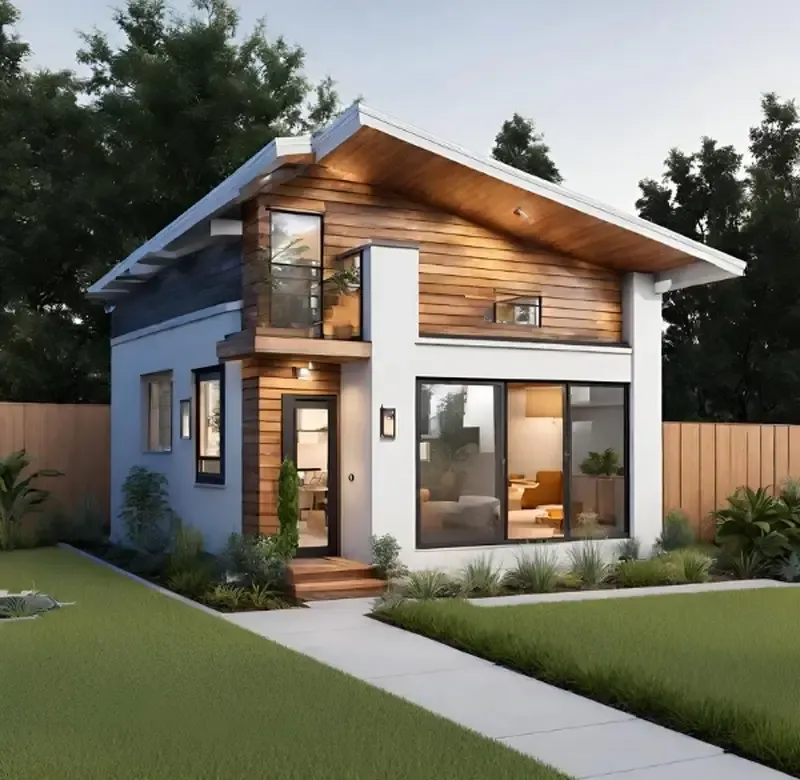 A modern two-story house with light blue-gray stucco lower level and warm brown wood siding on the upper floor. The home features floor-to-ceiling windows, a glass balcony, and sits on lush green lawn with mature trees in a peaceful suburban setting.